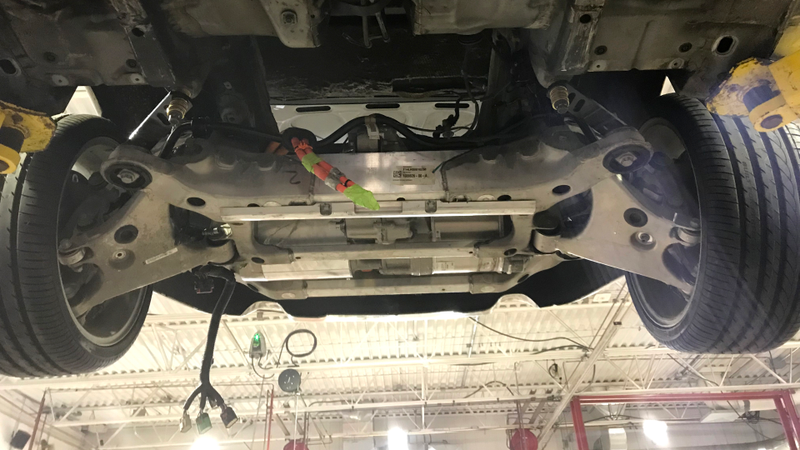 Fitting the rear axle assembly into the car.